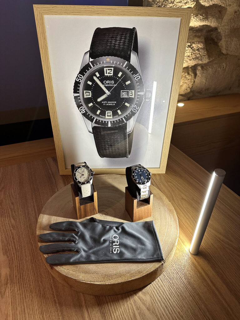 Montre Oris pr&eacute;sent&eacute;e sur son socle avec un gant de manipulation