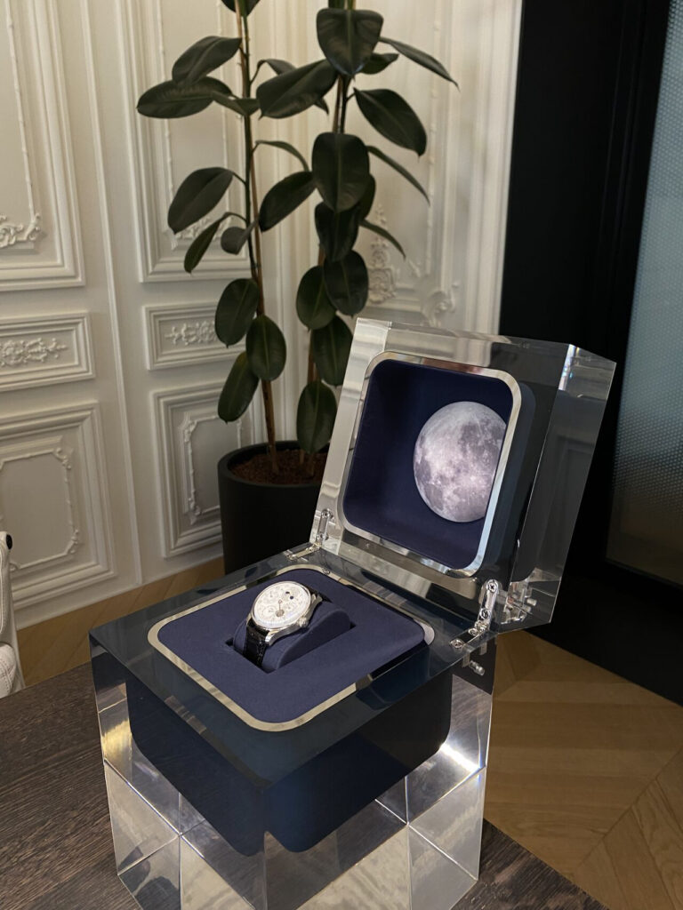 Montre IWC présentée sous vitrine devant un décor de phases de lune